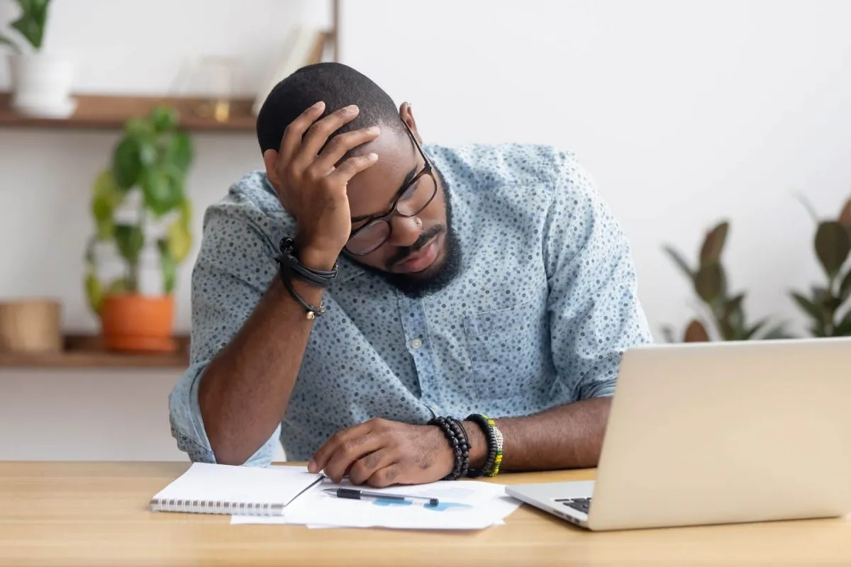 A man having difficulty concentrating while working at a desk