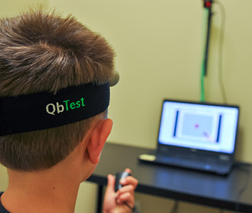 A young patient wearing a QbTest motion-tracking headband during a computerized ADHD assessment
